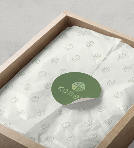 Tissue wrapped product with a simple green circular logo sticker, reflecting a clean, caring, and natural brand impression