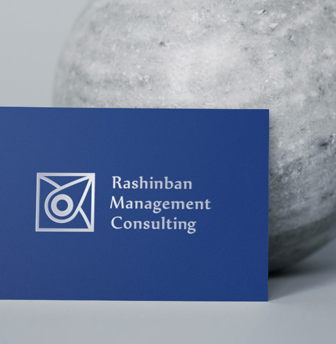 Close up of a blue business card with a clean professional logo design created by TMCreation displayed against a stone background