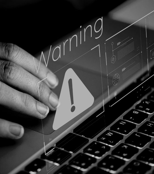 A close up of a laptop warning symbol indicating the risks of outdated plugins and missing updates on a website