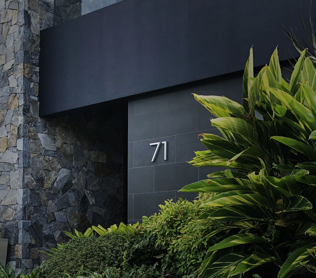 Modern architectural entrance with stone and greenery, designed as a professional studio office exterior