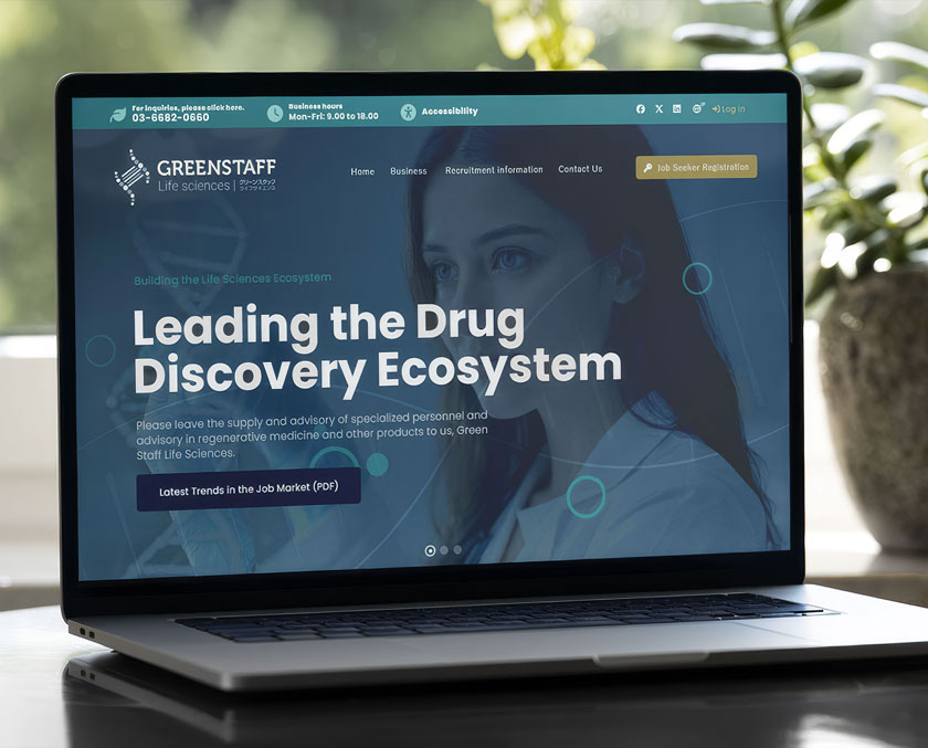 青や緑を基調としたクールな配色のウェブサイト。明るいデスク上のノートパソコンに映る、清潔感のあるモダンなウェブデザイン。