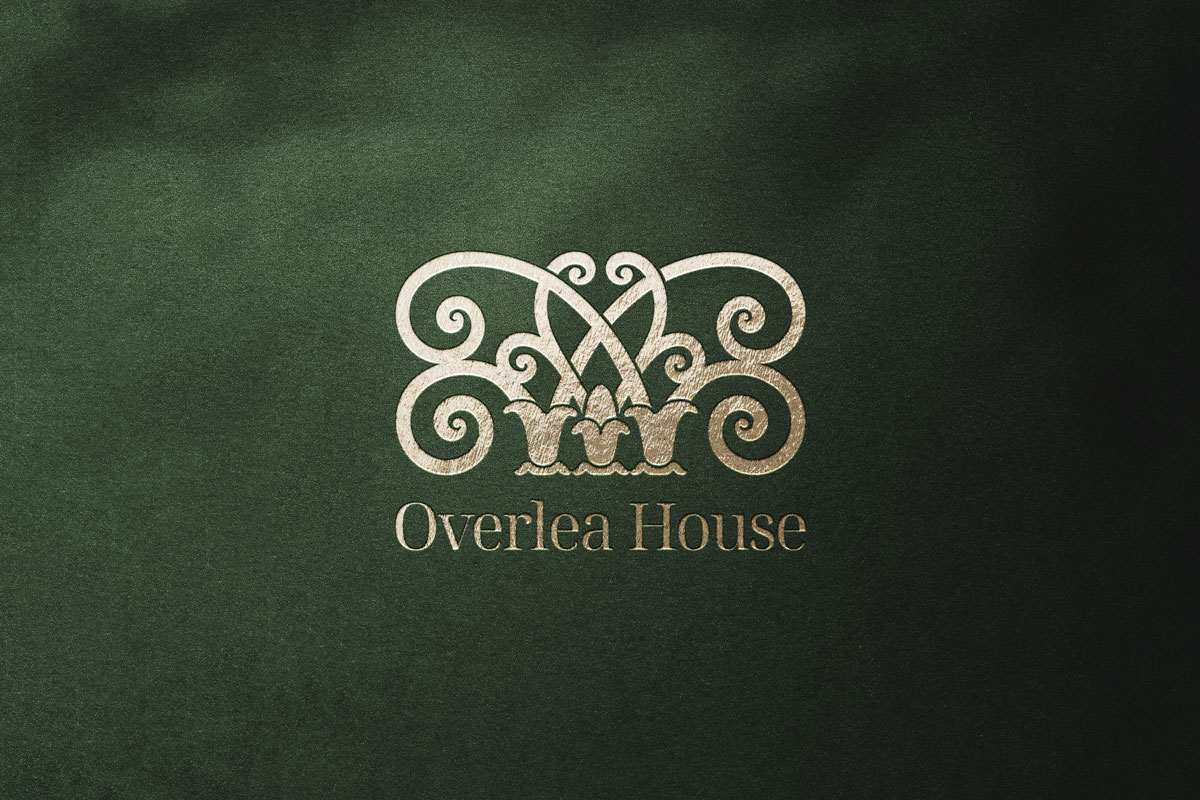 Overlea Houseのゴールド・ロゴデザイン。ダークグリーンとの組み合わせで優雅さを演出